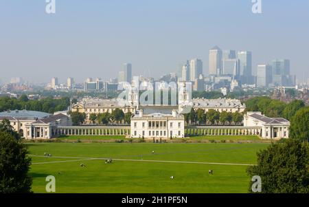 GREENWICH, Großbritannien - CA. SEPTEMBER 2013: Das National Maritime Museum und Canary Wharf im Hintergrund, vom Greenwhich Park aus gesehen. Stockfoto