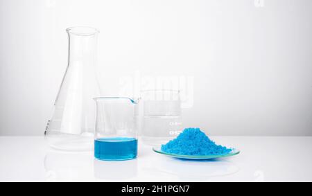 Nahaufnahme anorganischer Chemikalien auf weißem Labortisch. Kupfer(II)-Sulfat, Alkohol. Chemische Zutat für Kosmetika und Körperpflegeprodukte. Stockfoto