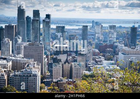 Blick auf die Innenstadt von Montreal vom Mont Royal aus mit einem Wandgemälde des Montrealer Ureinwohner Leonard Cohen und der Champlain-Brücke über den St. Lawrence River. Stockfoto