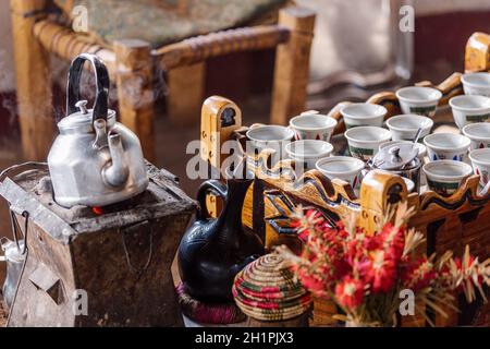 Platz mit Tassen äthiopischen Kaffee mit aromatischer Essenz namens buna serviert. Weihrauch und Myrrhe entzündet von einer heißen Kohle, um Rauch zu erzeugen, die sich entwirke Stockfoto