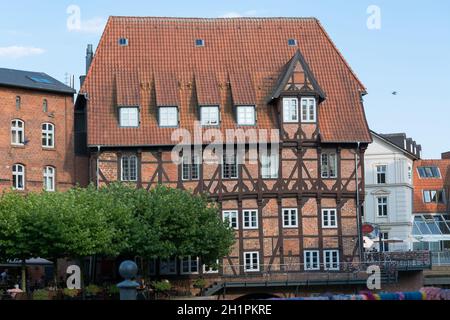 LÜNEBURG, NIEDERSACHSEN, DEUTSCHLAND - 27. JULI 2018: Fachwerkhäuser aus rotem Backstein in der Nähe des Flusses am alten Hafen Lüneburg Stockfoto