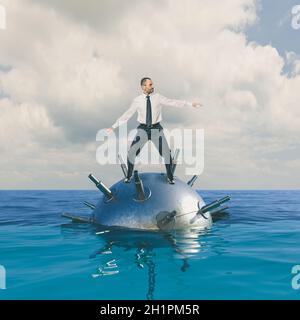 Geschäftsmann fährt eine Mine ins Meer. Konzept von Gefahr und Risiko. Stockfoto