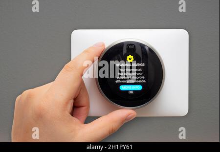 Calgary, Alberta, Kanada. Februar 11 2021. Eine Person, die ein Nest Thermostat aufsetzt, um im Winter saisonale Einsparungen zu erzielen. Stockfoto