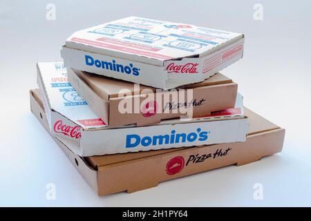 Calgary, Alberta, Kanada. Februar 15, 2021. Pizza Hut und Domino's Pizza Boxen übereinander auf einem klaren Hintergrund. Stockfoto