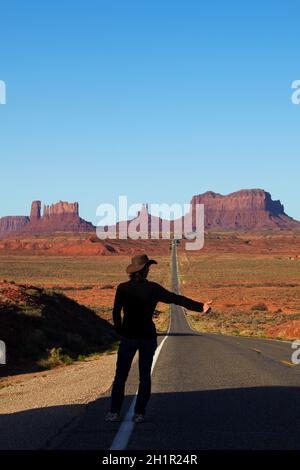 Tramper auf der U.S. Route 163 in Richtung Monument Valley, Navajo Nation, Utah, nahe der Grenze zu Arizona, USA (Model-Release) Stockfoto