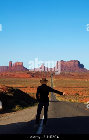 Tramper auf der U.S. Route 163 in Richtung Monument Valley, Navajo Nation, Utah, nahe der Grenze zu Arizona, USA (Model-Release) Stockfoto