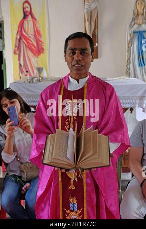 Der Priester hält die missale, katholische Kirche in Chunakhali, Westbengalen, Indien Stockfoto