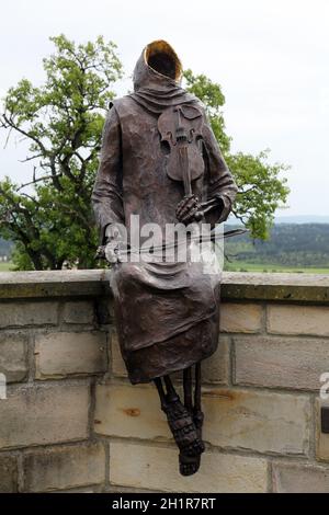 Mönch Maurus mit einer Geige, sitzen auf der Mauer um die Kirche in Pfarrkirche St. Jakob in Hohenberg, Deutschland Stockfoto