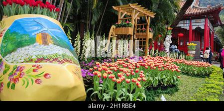 Taipei, Taiwan, Februar 26 2021: Dekorative holländische Mühle und ein Boot mit zwei Figuren am Eingang zum Shilin Residence Park für die Tulip Show 2021 Stockfoto