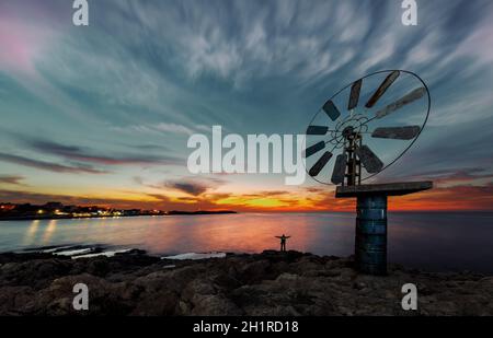 Wunderschöne Aussicht auf eine große Windmühle über Sonnenuntergang Himmel Hintergrund an der Küste. Anfeh. Libanon Stockfoto