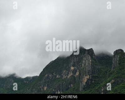 Wolken und Nebel bedecken Kalksteinberg in der Regenzeit, grüner Wald und Felsen im Khao Sam ROI Yot National Park, Thailand Stockfoto