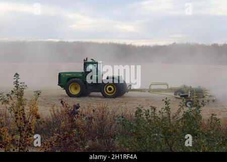 BONNYVILE, ALBERTA, KANADA - 10. SEPTEMBER 2020: Ein lokaler Landwirt in John Deere Traktor arbeitet mit einem Kegelman Stawmaster zusammen, um nach der Ernte ein Feld zu egeln Stockfoto