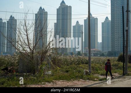 Ein älterer Dorfbewohner geht vor die Evergrande-Wohnimmobilien im Bezirk Wuqing, Tianjin, China. 19-Okt-2021 Stockfoto