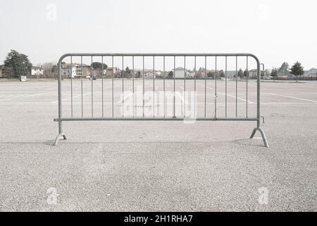 Eine mobile Metallschranke auf einem leeren Parkplatz Stockfoto