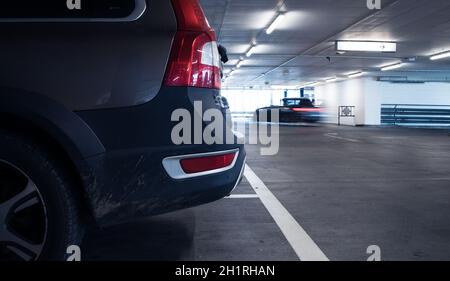 Parkplätze in der Tiefgarage. Autos in der Garage, ohne Leute geparkt. Viele Autos in der Garage. Tiefgarage mit Autos (Farbe getonte Bild) Stockfoto