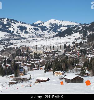 Skipiste und Blick auf Gstaad im Winter Stockfoto