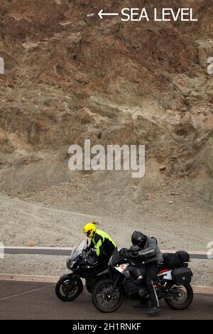 Motorräder mit dem Meeresspiegelschild, 282 Fuß / 86 m über dem Badwater Basin, dem niedrigsten Land in Nordamerika, Death Valley National Park, Mojave Desert, Califo Stockfoto