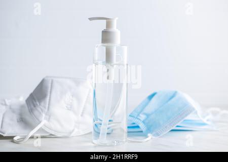 Coronavirus Prävention Hand Desinfektionsmittel und kn95 Atemschutzmaske. Händedesinfektionsgel in Pumpenflasche auf weißem Tisch. Stockfoto