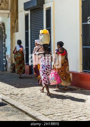 Antsiranana, Madagaskar - 20. Dezember 2015: Unidentified madagassische Frauen gehen und in Antsiranana (Diego Taschen auf dem Kopf und ein Baby auf dem Rücken tragen Stockfoto