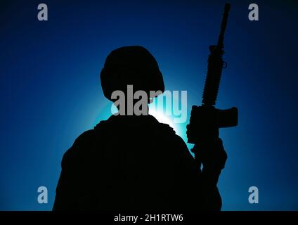 Nacht Silhouette der Armee spezielle Operationen Streitkräfte Soldat mit Dienstgewehr auf dem Hintergrund des Nachthimmels mit Mond und Sternen stehen. Moderne Kriegsführung Stockfoto