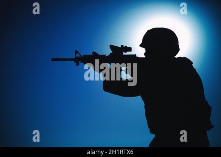 Moderne Armee Infanterie Soldat, Küstenwache Sturmgewehr mit Kollimator Anblick in der Nacht anvisieren. Spezialoperationen Forces Fighter Eingriffs en Stockfoto