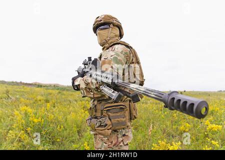 Ausgerüsteter und bewaffneter Soldat der Spezialeinheiten mit einstehender Riffel Das Feld Stockfoto