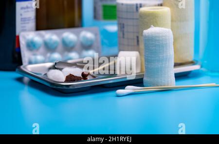 Wundpflege-Verbandsset. Selektiver Fokus-Baumwollstab und elastischer konformer Verband, Edelstahlplatte auf Blur-Zepern, Verband, Baumwollball mit Stockfoto