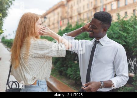 Ellenbogenstoß. Neue Begrüßung, um die Ausbreitung des Coronavirus zu vermeiden. Der schwarze Mann und die kaukasische Frau verwenden zum Gruß Ellbogen statt Handflächen. Stockfoto