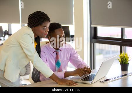 Zwei junge geschäftsanraine aus afrika diskutieren über einen Laptop. Stockfoto
