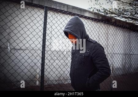 Junge Straßenbande mit Maske im Park, soziales Problem Stockfoto