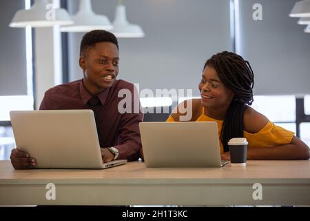 Zwei junge geschäftsanraine aus afrika diskutieren über einen Laptop. Stockfoto