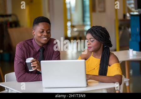 Zwei junge geschäftsanraine aus afrika diskutieren über einen Laptop. Stockfoto