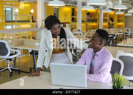 Zwei junge geschäftsanraine aus afrika diskutieren über einen Laptop. Stockfoto