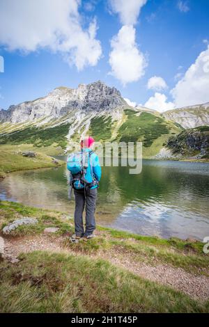 Weibliche blond Bergsteiger mit Rucksack ist die Aussicht genießen Stockfoto