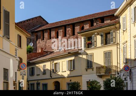 Stadtbild einer kleinen Stadt mit einer Renaissance-Burgmauer über den Dächern alter Häuser, aufgenommen an einem hellen Sommertag in Vigevano, Pavia, Lombardei, Italien Stockfoto