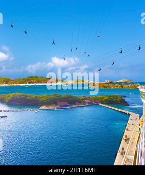 Menschen, die auf der karibischen Insel Labadee auf Haiti mit hoher Zipline fliegen. Die ariale Ansicht vom Abstieg des abstrakten Kreuzschiffs auf caribbean Haiti auf sonniger Höhe Stockfoto