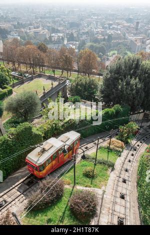 Obere Zeile in Bergamo Stadt Standseilbahn (funicolare Citta Alta). Rote Standseilbahn verbindet alte Obere Stadt und neu. Malerische Aussicht auf das historische Zentrum von Bergamo. Stockfoto