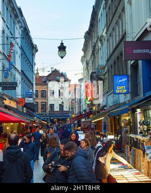 BRÜSSEL, BELGIEN - 06. OKTOBER 2019: Menschenmenge, die in der Dämmerung an der Einkaufsstraße der Altstadt von Brüssel spazieren Stockfoto