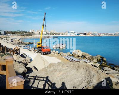 Laden eines Eisenabschnitts auf eine schwimmende Plattform. Bau des Piers. Kasachstan. Aktau. 08 Oktober 2019 Jahr. Arbeiten ohne Schutzequi Stockfoto