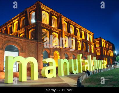 Riesige Buchstaben in Wort Manufactra in Lodz. Manufaktura Kunstzentrum, Einkaufszentrum und Freizeitkomplex in Lodz Polen. Schöne Stadtarchitektur mit Stockfoto