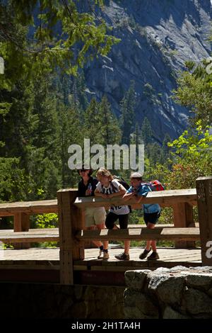 Fußgängerbrücke über den Merced River, auf dem Mist Trail, Yosemite National Park, Kalifornien, USA (Model Release) Stockfoto