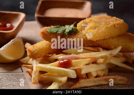 Traditionelles englisches Essen: Fisch und Chips. Gebratene Fischfilets und knusprige Pommes frites mit Ketchup und hausgemachter Tortersauce. Stockfoto