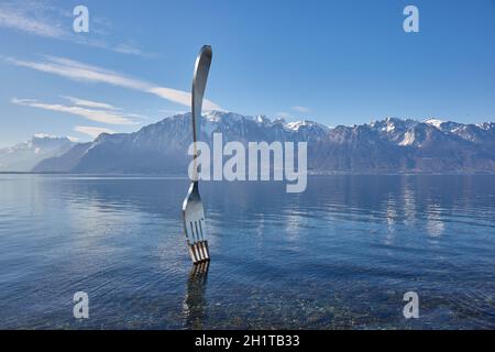 Vevey, Schweiz - um 2021: Riesige Stahlgabel-Kunstinstallation im Genfersee Teil des Alimentarium-Lebensmittelmuseums in Vevey, plätschernde Wasseroberfläche Stockfoto