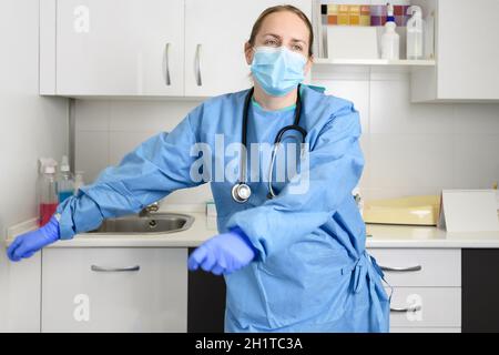 Positive Ärztin tanzt im Krankenhaus Zahnseide und feiert das Ende der Coronavirus-Pandemie. Hochwertige Fotos. Stockfoto