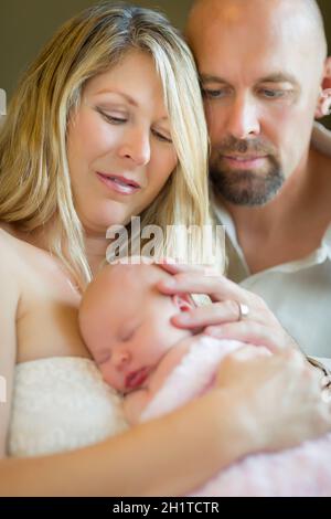 Schöne Junge Paar Hält Ihre Neugeborenen Schlafenden Baby Mädchen Innen. Stockfoto