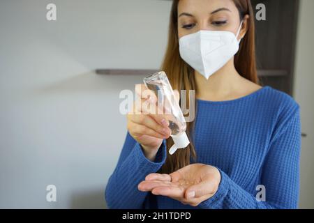 Nahaufnahme einer jungen Frau mit Alkoholgel Hände Desinfektionsmittel Tragen der FFP2 KN95 Gesichtsmaske im Innenbereich Stockfoto