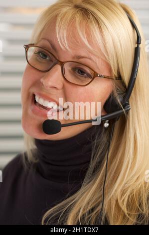 Attraktive Geschäftsfrau Gespräche über ihr Handy Kopfhörer. Stockfoto