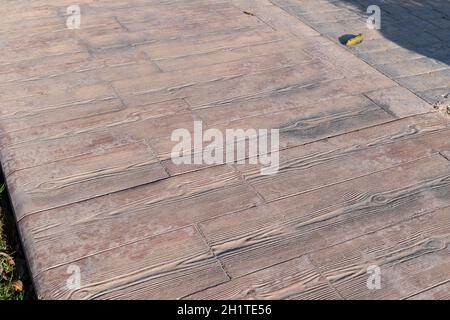 Gestempelte Betonpflaster im Freien, Holzlatten Muster, Bodenbelag außen, dekorative Textur von Zement Pflaster erscheinen die Streifen von Holz Stockfoto