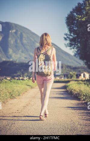 Junge Mädchen in der Overall mit Rucksack ist einen Spaziergang machen, Sommer Stockfoto