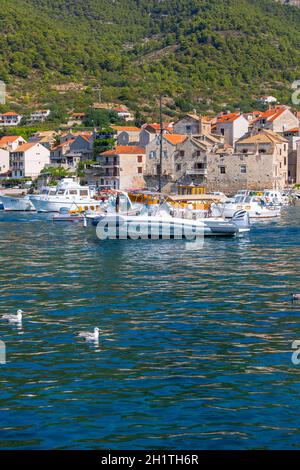 Komiza, Kroatien; Insel Vis - 5. September 2019: Küstenstadt aus dem 12. Jahrhundert auf der Insel Vis an der Adria, Blick auf den Hafen, festfahrende Boote Stockfoto